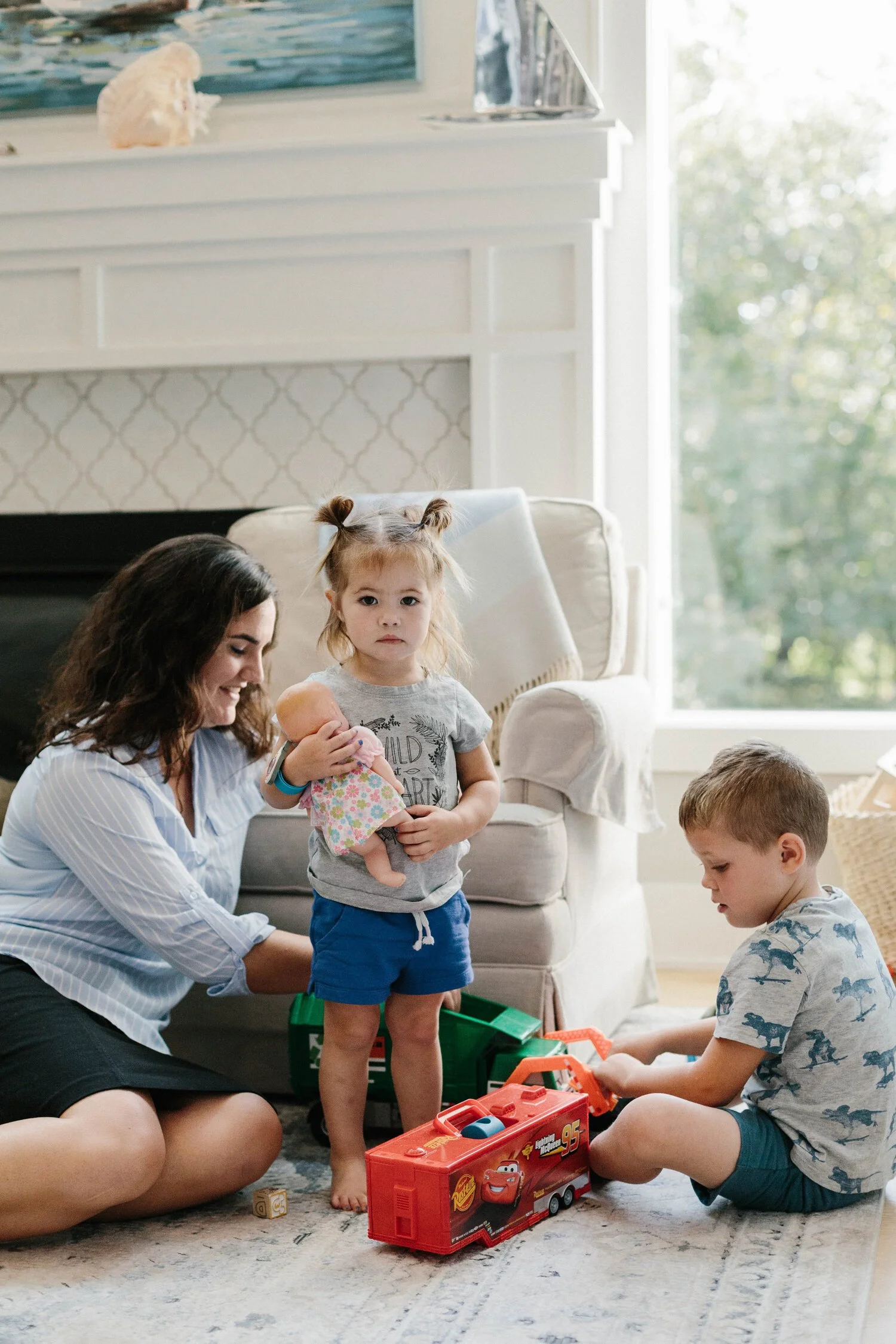 caregiver playing with young children demonstrating newborn development activities