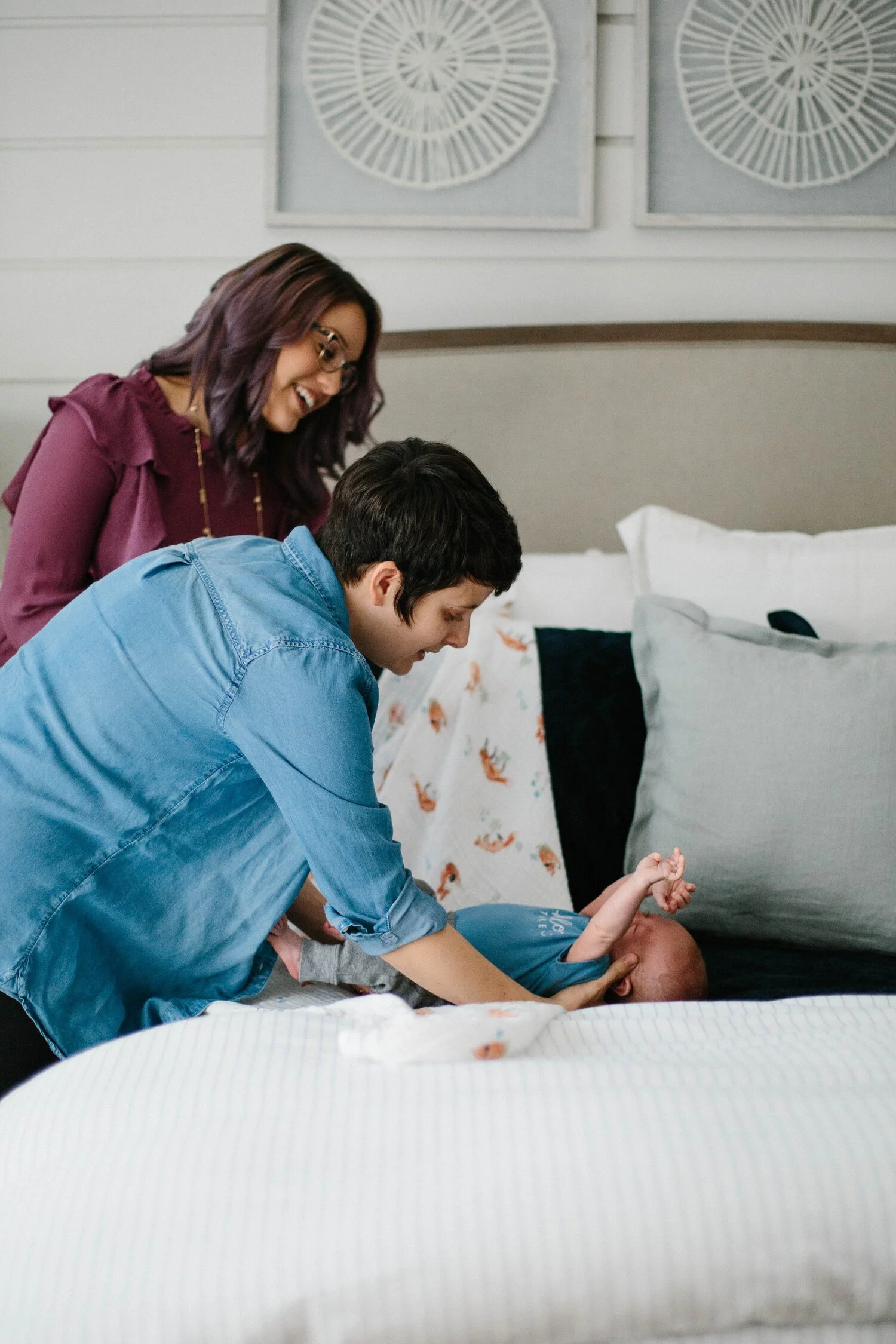 parents gently caring for newborn on bed using newborn care tips