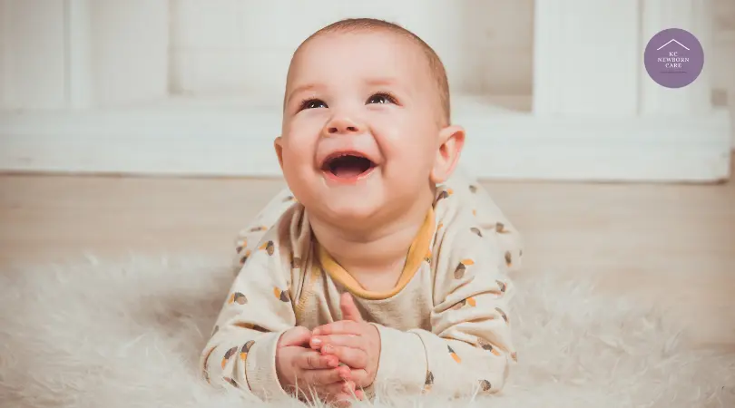 smiling baby lying on soft blanket during tummy time development activity